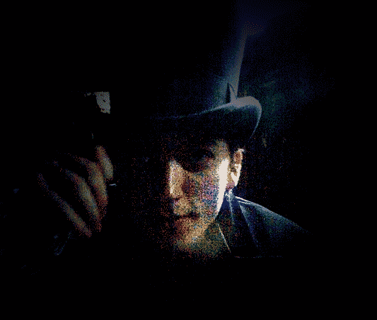 Michael Kostal in a top hat looking through a monocle for your page